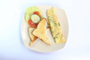 a white plate of food with a sandwich and chips at Sebrang Hills Bungalow in Nusa Penida