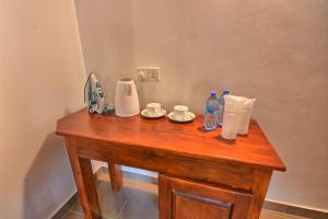 una mesa de madera con 2 botellas de agua y 2 platos en Dambulla Hills Resort en Dambulla
