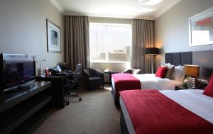 A bed or beds in a room at Ramada Downtown Abu Dhabi