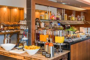 a restaurant with a counter with orange juice at Hotel Wolfsburg Centrum, Affiliated by Meliá in Wolfsburg