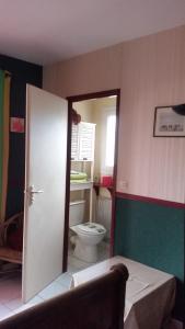 La salle de bains est pourvue de toilettes et d'une porte blanche. dans l'établissement Jodelle, à La Riche