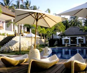a group of chairs and an umbrella next to a pool at Imaj Private Villas in Senggigi