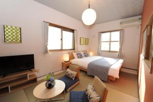 a bedroom with a bed and a tv and a table at Viale Jurakumawari in Kyoto