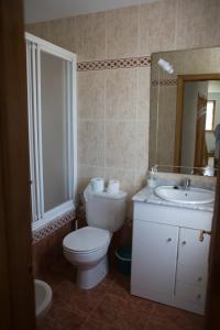 een badkamer met een toilet, een wastafel en een spiegel bij Casa Rural La Fueya in Oviñana