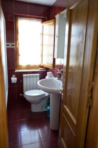 baño con lavabo y aseo y ventana en Casa Rural La Fueya, en Oviñana