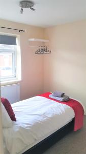 a bedroom with a bed with a red blanket on it at Swindon Old Town Duplex - EnterCloud9SA in Swindon