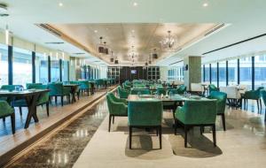 セブシティにあるbai Hotel Cebuのダイニングルーム(テーブル、緑の椅子付)