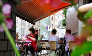a woman sitting at a table with a child in her lap at Pension am Park - Merseburg in Merseburg
