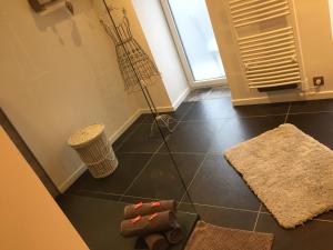 a bathroom with a black tiled floor with rugs at La maison du Lac in Spa +20 photos