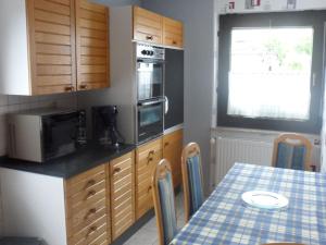 a kitchen with a table and a microwave at Ferienwohnung Eleonore Sauter in Meßstetten