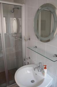 Un baño con lavabo, espejo y ducha. en Moringa Gardens # 03 E, en Swakopmund