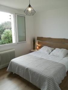 - une chambre avec un grand lit et une fenêtre dans l'établissement Appartement Lumineux Vue Panoramique, à Ajaccio