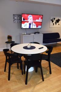 a table and chairs in a living room with a tv at Västerhöjdsgården in Skövde