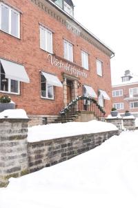 un bâtiment en briques avec de la neige devant lui dans l'établissement Västerhöjdsgården, à Skövde