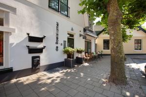 a building with a tree in front of it at Boutique Hotel De Raetskamer in Noordwijkerhout