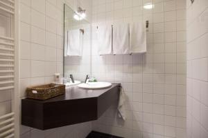 a white bathroom with a sink and a mirror at Boutique Hotel De Raetskamer in Noordwijkerhout +27 photos