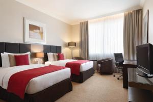 A bed or beds in a room at Ramada Downtown Abu Dhabi