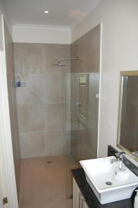 a bathroom with a glass shower and a sink at Longacre Olive & Vineyard Estate in Langebaan +28 photos