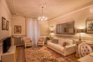een woonkamer met een bank, stoelen en een spiegel bij Domus Verona - Incantevole residenza difronte a casa Giulietta in Verona