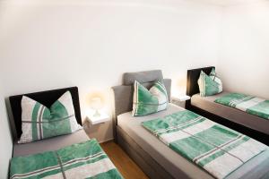 a room with two beds with green and white pillows at Das Quartier in Weitendorf