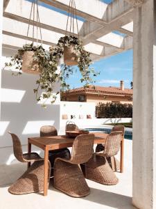 einen Holztisch und Stühle auf einer Terrasse in der Unterkunft Villa Fernweh - Delta de l'Ebre in Riumar