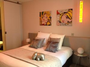 een slaapkamer met een bed met drie schilderijen aan de muur bij La Maison de Léa in Parijs