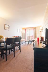 a living room with a table and chairs and a couch at Résidence Pierre & Vacances Le Tikal in Val Thorens