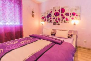 a bedroom with two beds with purple and white sheets at Pension Kuhn in Rust