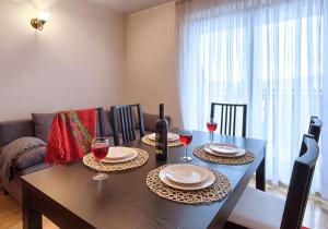 stół jadalny z dwoma talerzami i kieliszkami do wina w obiekcie VisitZakopane - Paris Apartment w Zakopanem