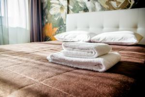 sterta ręczników na łóżku w obiekcie Hotel Cambridge w mieście Iżewsk