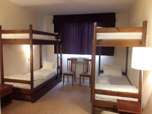a room with three bunk beds and a table at Hotel 7ya in Krasnosilske