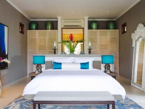 - une chambre avec un grand lit blanc et des oreillers bleus dans l'établissement The Arsana Estate by Elite Havens, à Tabanan