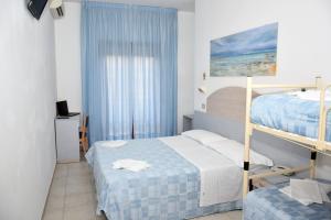 アルバ・アドリアティカにあるHotel Petite Fleurのベッドルーム1室(二段ベッド2台、窓付)が備わります。