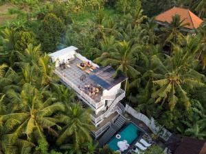 una vista sul mare di un resort con piscina e palme di Pillow Inn Ubud ad Ubud