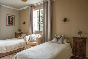 een slaapkamer met 2 bedden, een stoel en een raam bij Casa Vanella in Casamaccioli
