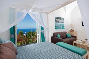 a bedroom with a bed and a view of the ocean at Capri Wine Hotel in Capri
