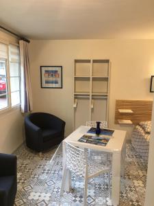 a living room with a white table and a chair at A l'Ancre Bleue in Le Tréport