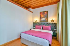 a bedroom with a large bed with pink pillows at Istanbul Life Hotel in Istanbul
