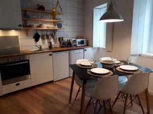 アングラ・ド・エロイーズモにあるCasa da Séのキッチン(黒いテーブルと椅子付)、キッチン(白いキャビネット付)