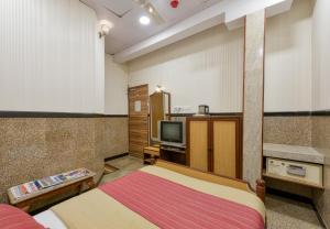 a small room with a bed and a tv at Hotel Royal Castle in Mumbai +45 photos