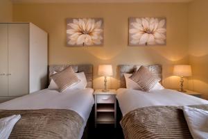 Dos camas una al lado de la otra en un dormitorio. en Wolverhampton City Stay II, en Wolverhampton