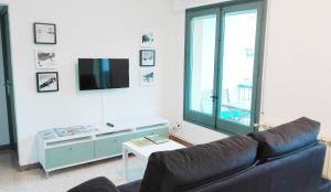 sala de estar con sofá y TV en Apartament Nou Fontalba, en Ribes de Freser