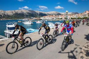 a group of people riding bikes down a road at Apartments MYRJAM in Baška