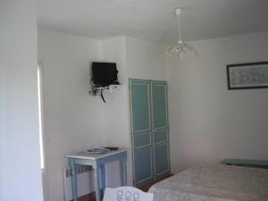 トゥルトゥルにあるle studio bleuのベッドルーム1室(ベッド1台、壁掛けテレビ付)