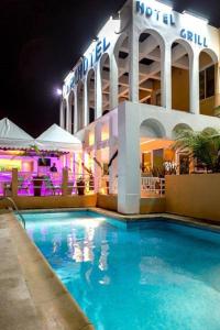 a hotel with a swimming pool in front of a building at Archotel in Dakar