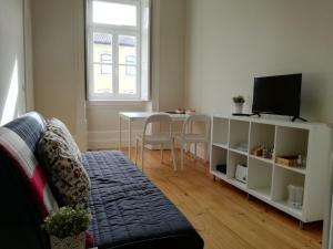 a living room with a couch and a table at Ah33 - Estúdios in Coimbra