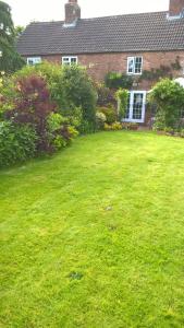 um quintal de uma casa com um relvado verde em Mountain Ash em Horncastle