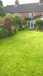 a yard of a house with a green lawn at Mountain Ash in Horncastle +2 photos