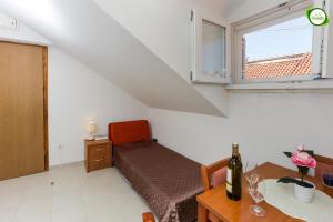 a room with a bed and a table and a window at Apartment Larica in Dubrovnik