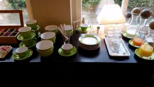 a table with green cups and plates and a lamp at Pension 'Das kleine Landhaus' in Oberhaverbeck